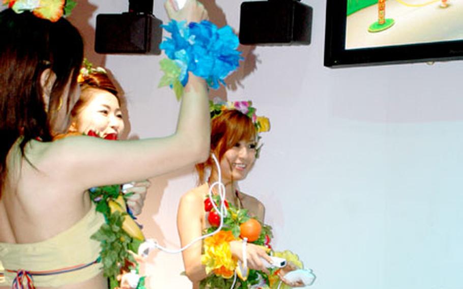 Booth babes demonstrate how to play a jump rope mini-game on Sega’s new “Super Monkey Ball” for the Nintendo Wii.