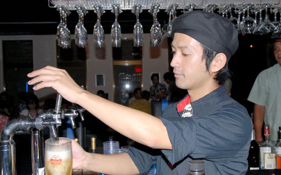 A bartender at Cure in Chatan, Okinawa, fills another beer order.