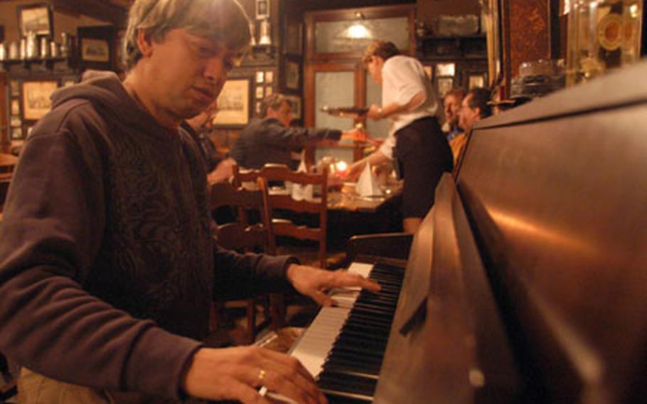 Rudi Scheffler, piano man at the Zum Roten Ochsen, taps out a tune at dinner time Feb. 28. Scheffler has played piano at the Ochsen - a student pub - for the past 13 years and was there for the building&#39;s 300th anniversary in 2003.
