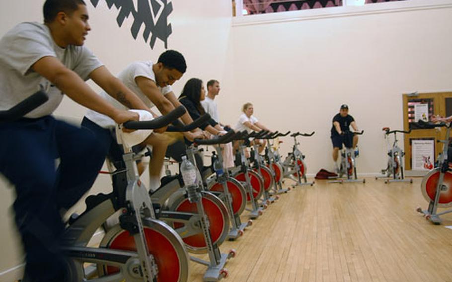 Participants in a spinning class at the Northside gym on RAF Mildenhall, England, warm up for a recent lunchtime spinning class.