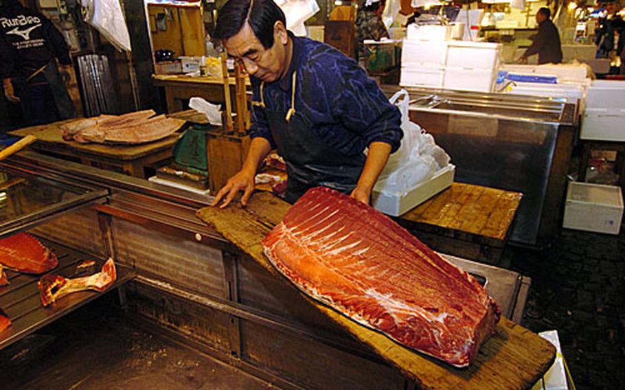 Private vendors slice up fish to sale to customers during the work day at the market. The tuna auction in the inner market is held inside a warehouse full of frozen fish carcasses that are routinely sold at prices that can run from $10,000 and more.