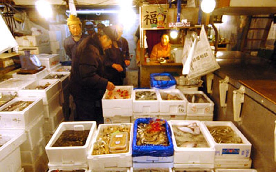 Private vendors organize their fish for sale in large coolers at the market.