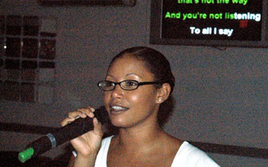 Senior Airman Erinn Powell gives karaoke night a go at the enlisted half of the base club. Airmen can sing along with the music once a week.