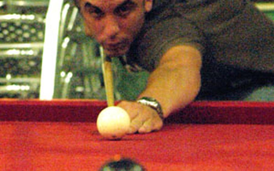 Airman 1st Class Andy Schreacke lines up a shot while playing billiards at the enlisted half of the base club at Incirlik Air Base.