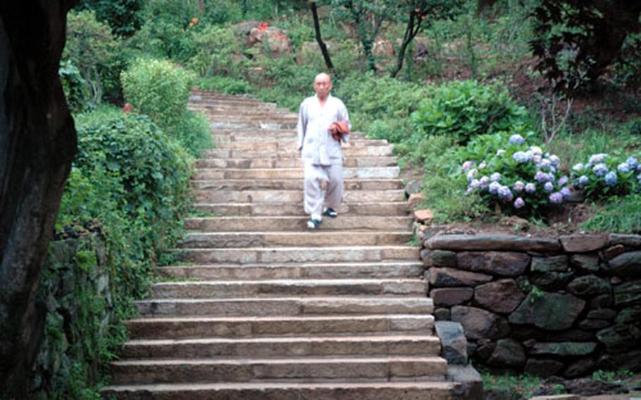 A monk walks through the grounds at Jeondeungsa Temple. The temple grounds were established in the 13th century. It was the place where a canon of 81,340 woodblocks were carved, one of the most important texts in Buddhism. That collection now resides at Haeinsa Temple, near Taegu.