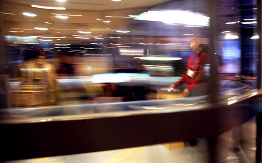 Visitors take a spin and throw a ball in the rotating room at the museum, allowing them to see first-hand the effects of inertia on moving objects. The sign, inset, explains the room. Many of the signs are in English, too.