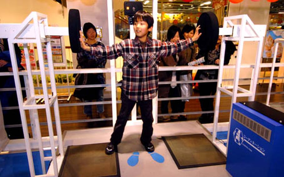 A youn patron plays a game set up for testing reflex.