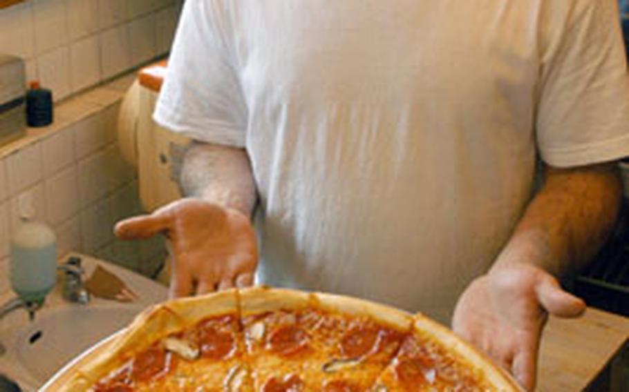 Alex Knight serves up traditional American pizzas, with toppings including pepperoni and mushrooms, at I Love NY Pizza near Yokosuka Naval Base, Japan.