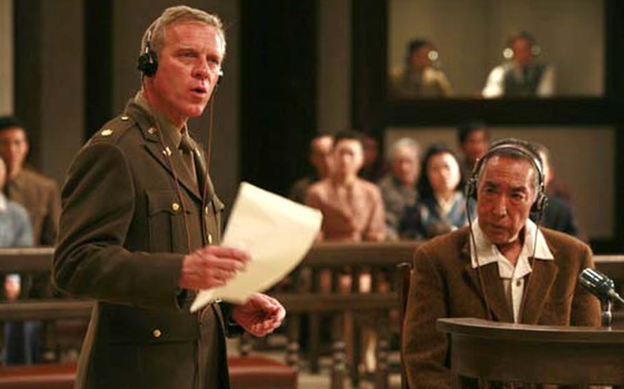 Chief Prosecutor Attorney Richard F. Burnett (Fred McQueen) is questioning while Lt. Gen. Tasuku Okada (Makoto Fujita) is listening at the Yokohama Distrcit Court.