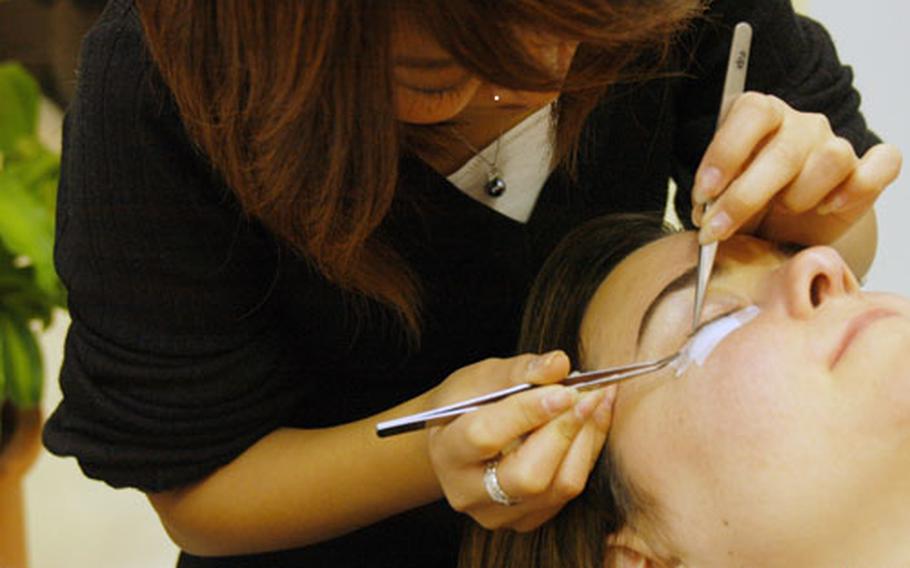 Stylist Miako Suzuki applies eyelash extensions to Teri Weaver in Yokosuka. Japan. Fibers are attached to the lash near the base of the eyelid.