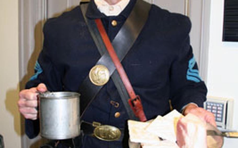Greg Hampton, a professor at the Army Management Staff College at Fort Belvoir, Va., and a Civil War re-enactor, offers a typical day’s field diet for a Union Army soldier — coffee, salt pork and hardtack — during a recent Army-sponsored demonstration on combat feeding at the Pentagon.