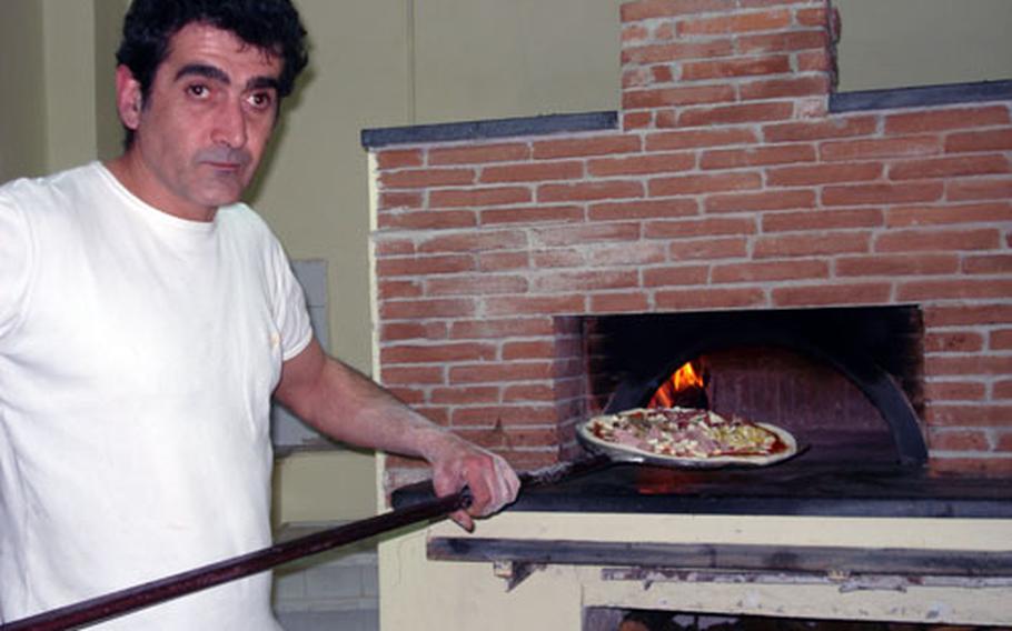 Antonio Quaranta, pizzaiolo at Pizzeria al Giardino in Pozzuoli, slides a pizza to be cooked into the brick oven, where temperatures hover between 750 and 850 degrees Fahrenheit.