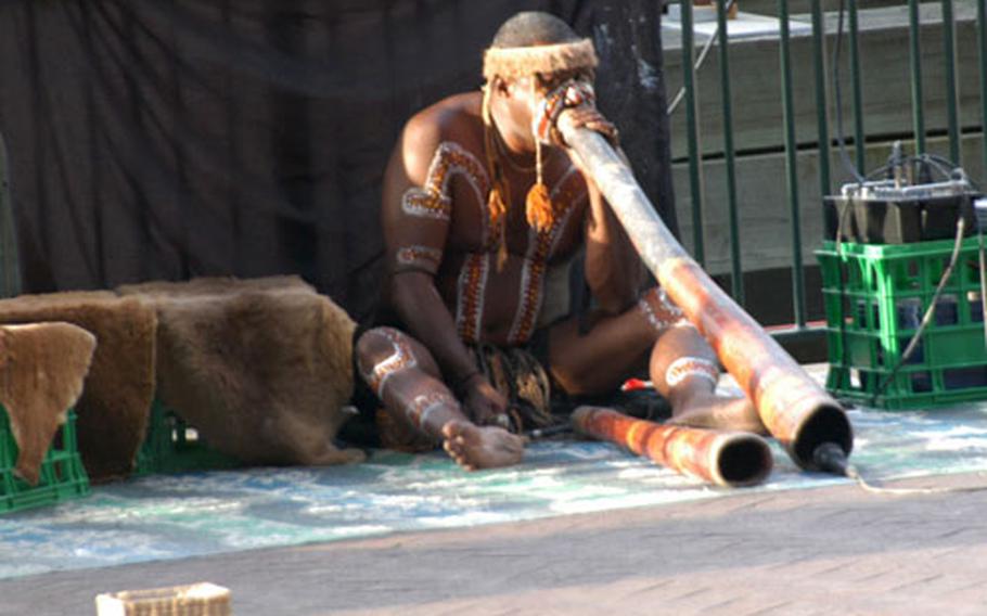 An Aboriginal man plays a traditional instrument at Circular Quay near Sydney Harbour.