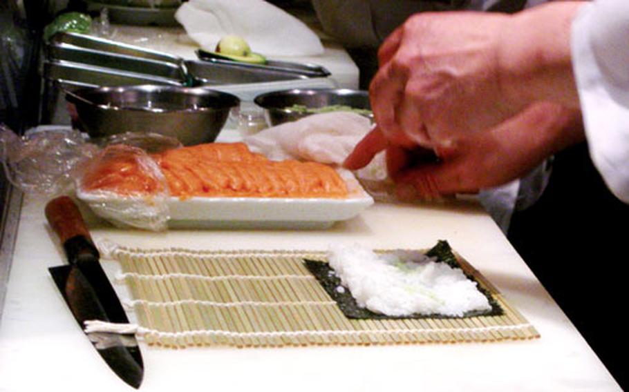 A Japanese sushi chef prepares his station at a restaurant in Tokyo. Kaiten Sushi restaurants are quite popular in Japan. The sushi is placed on a conveyor belt for patrons to pick up and eat.