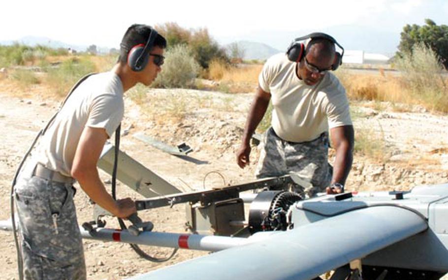 Sgt. Anh Huynh (left), 29, from Philadelphia, and Staff Sgt. Alton Jefferson, 29, from Gordon Heights, N.Y., both of Company B, 173rd Airborne Brigade Combat Team Special Troops Battalion, man the starter for a Shadow unmanned aerial vehicle.