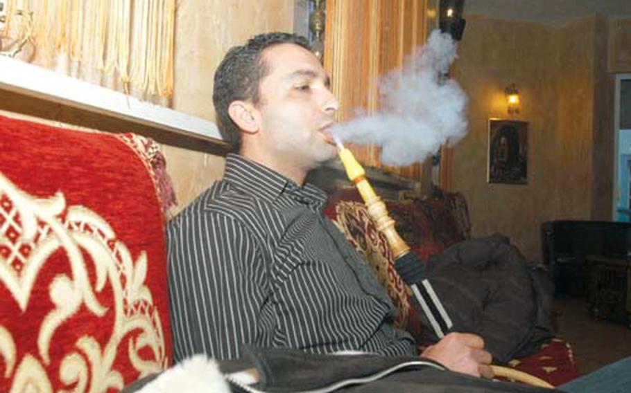 Chikh Anounr-Tunesien blows smoke from a hookah. He says he likes Dubai in St. Wendel, Germany, because “it’s traditional.”