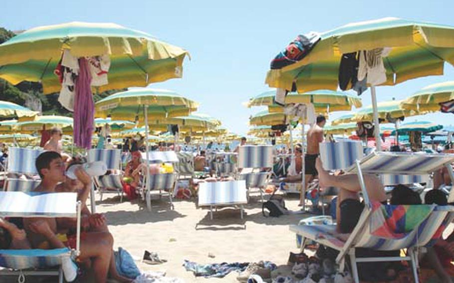 An Italian beach is crowded during October as Italians and tourists flock to the sea for their holiday. Author Barzini dissects the culture of these people in “The Italians.”