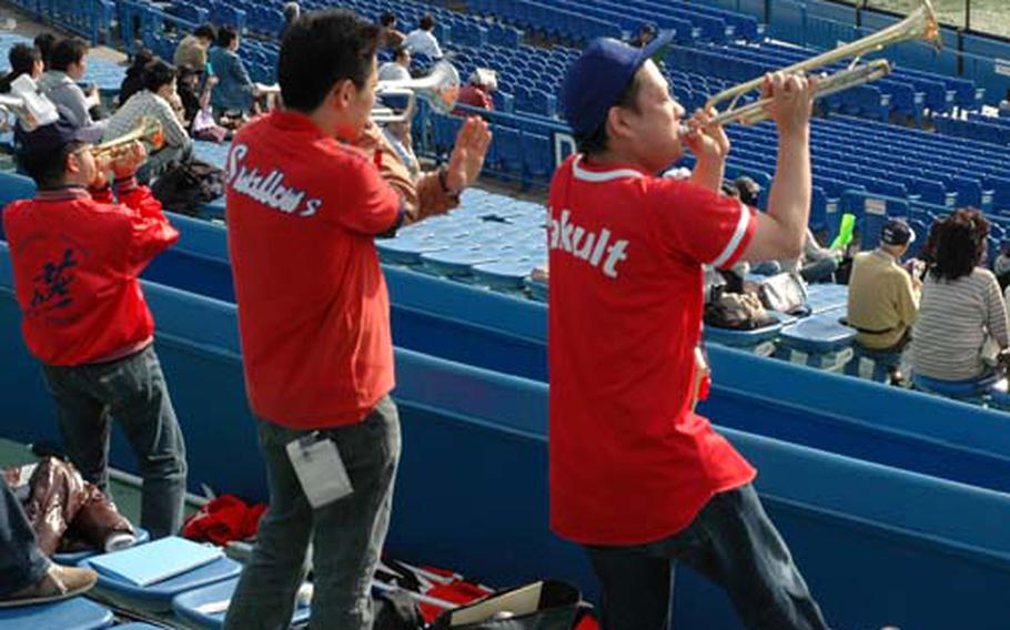 Yakult Swallows fans play trumpets while cheering for the team that played against Saitama Seibu Lions at Jingu Stadium in Tokyo.