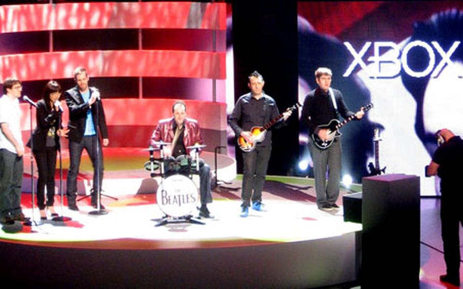 The "Harmonix House Band" uses plastic "Rock Band" controllers to perform the Beatles’ "Day Tripper," which will be part of "The Beatles Rock Band" when it is released later this year. The band performed at the Microsoft press briefing Monday at the Electronic Entertainment Expo in Los Angeles.