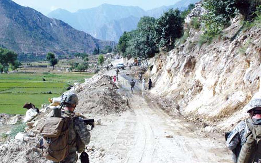 First Lt. Jonathan Brostrom, left, leads a patrol through a village near Camp Blessing on June 22, 2008. Three weeks later, Brostrom would be one of nine soldiers in his company to die while defending a vehicle patrol base in Wanat. He was posthumously awarded the Silver Star.