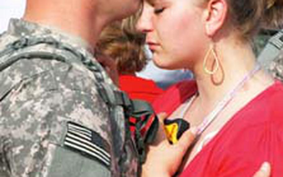 Spc. Dennis Singleton of Company B, 120th Combined Arms Battalion, comforts his fiancee, Jessica Harron of Hendersonville, N.C., as he prepares to board a bus.