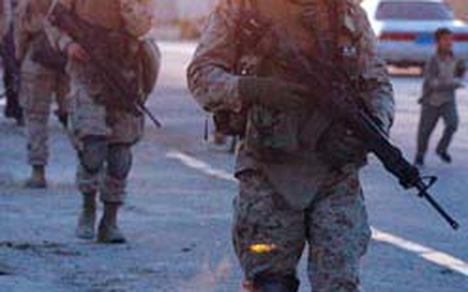 Marines of the 2nd Battalion, 4th Regiment patrol the street during a night foot patrol in Ramadi, Iraq, on April 6, 2004. Donovan Campbell’s actions that day earned him a Bronze Star with “V” device.