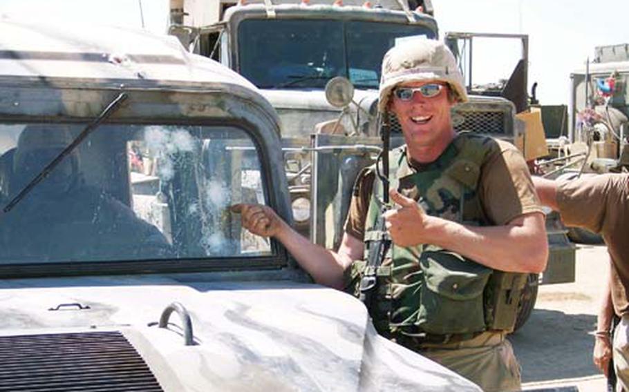 At Baghdad International Airport in Iraq in April 2004, then-Spc. Bryan K. Noble of the 1487th Transportation Company, Ohio Army National Guard, points to the windshield of his Humvee, which earlier that day was hit by seven AK-47 rounds fired by an insurgent sniper.