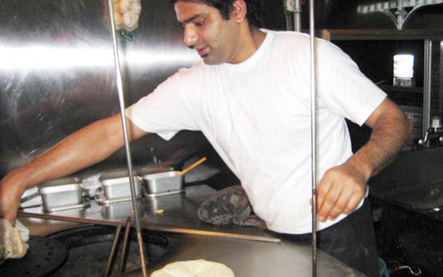 Cook Raju Prasadkandel bakes naan. A kitchen window gives diners a firsthand look at how the flatbread is made.