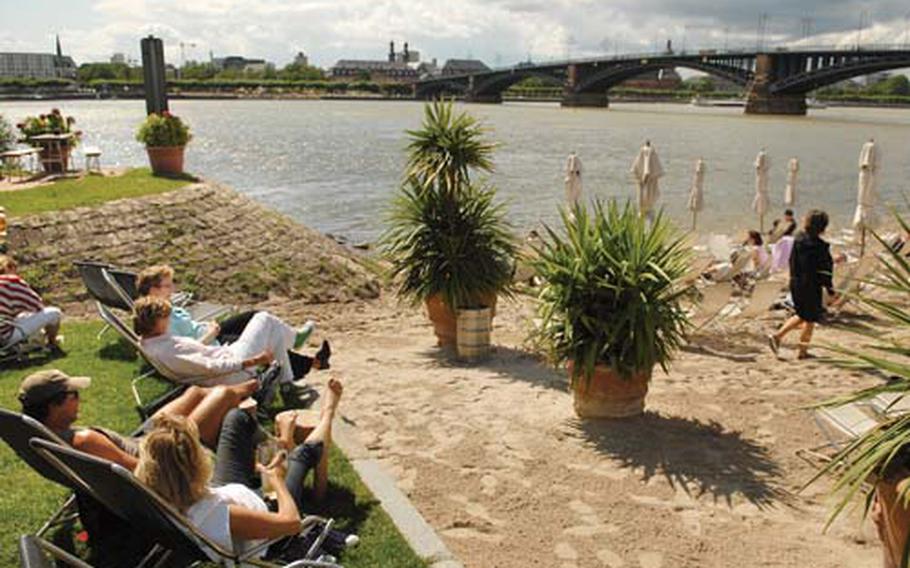 Locals soak in the sun near the Rhine river at the Kasteler beach nestled in metropolitan Mainz-Kastel.