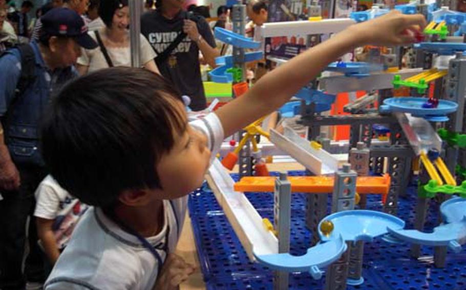 A Japanese boy has fun placing a marble on Iwaya’s Cological Set July 18 at the International Tokyo Toy Show.