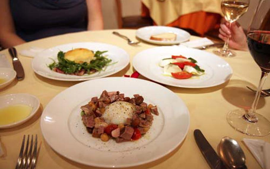 Appetizer choices at La Lingua Ochiai include roasted lamb and bean salad with a poached egg, front, and caprese.