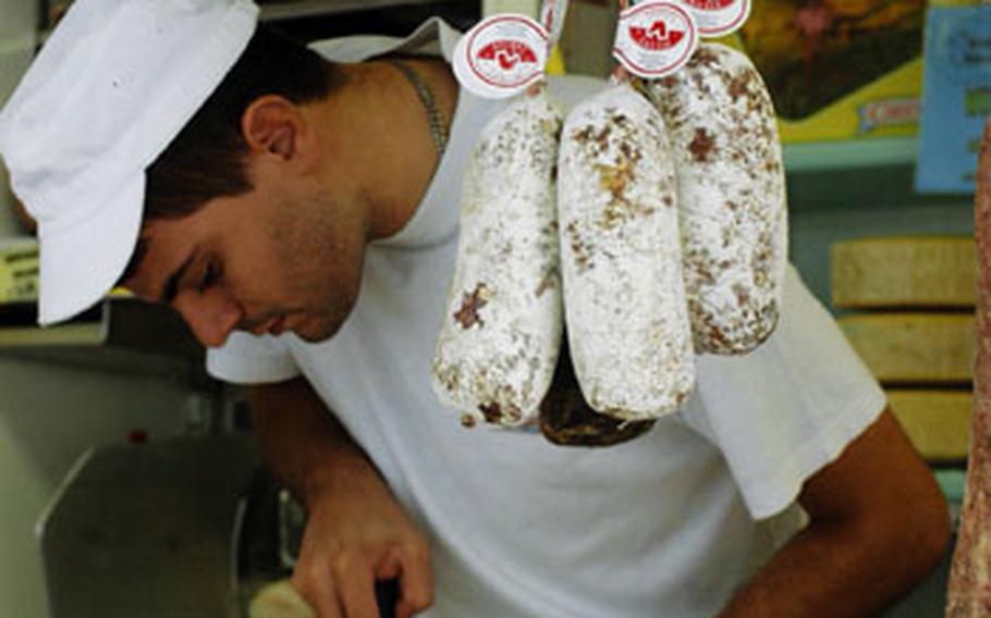 If the cheese that this Italian shopkeeper is slicing doesn’t suit your taste, you can always try the horse meat sausage that’s hanging next to him.