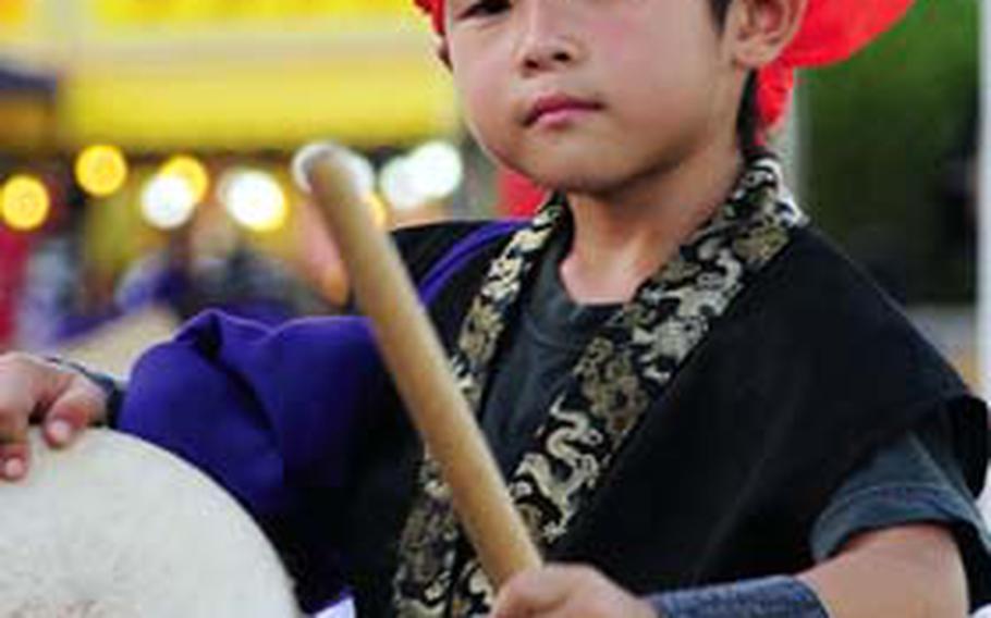 A young boy warms up with his drum.