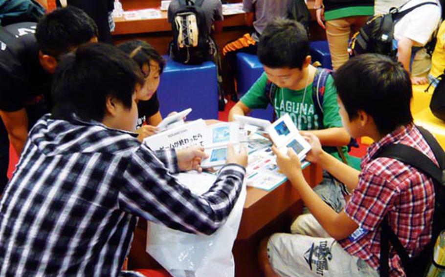 Children check out the Nintendo DS games at Square Enix booth set up for children during the Tokyo Game Show.