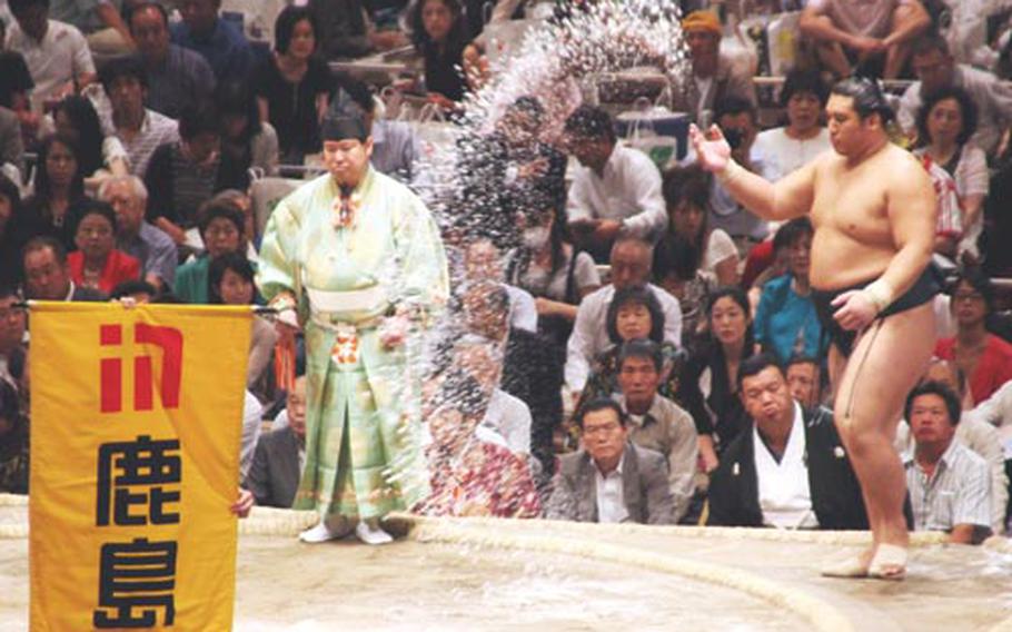 Sumo wrestler Homasho tosses a handful of salt into the ring (dohyo) as part of a purfication ritual to clense the ring at the Ryogoku Kokugikan on the eighth day of the 15 day of the tournament or "basho" as it is known, Sept. 20.