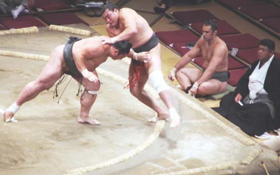 Two Sumo wrestlers battle it out during the Jonokuchi (lowest ranking) matches at the Ryogoku Kokugikan on the eighth day of the 15 day of the tournament or "basho" as it is known, Sept. 20 . Jonokuchi matches begin early in the morning often to smaller crowds. All Sumo wrestlers begin at this level and is left to work themselves up to a higher level.