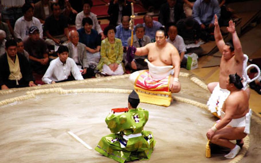 Yokozuna Hakuho (center) performs the ring entering ceremony of the Grand Champion or dohyo-iri at Ryogoku Kokugikan on the eighth day of the 15 day of the tournament or "basho" as it is known, Sept. 20.