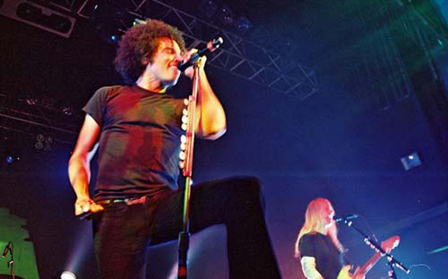 Newcomer William DuVall, left, takes on the lead vocals formerly sung by Layne Staley in Alice in Chains. Guitarist Jerry Cantrell, right, plays during the group’s recent performance at the Forum in London.