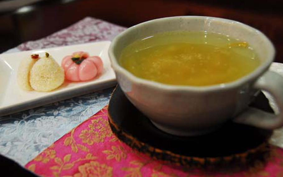 A cup of citron tea and two rice cakes at Jilsiru Tteok Cafe.