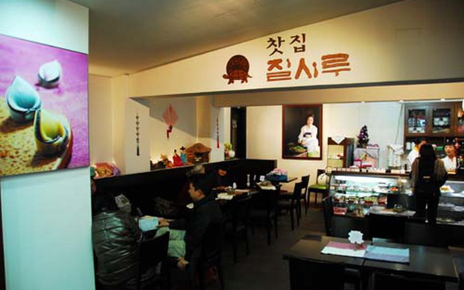 Customers order and eat Inside the Jilsiru Tteok Cafe in Insadong. On the wall, left, is a photo of a style of rice cake sold at the cafe.