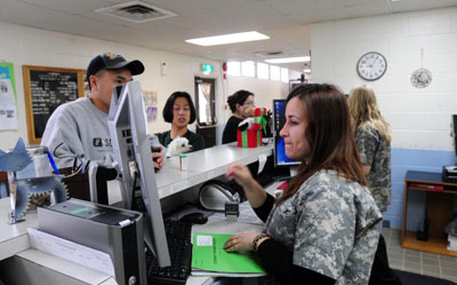 Jonelle Judge and Brittany Jungewaelter check in pet owners waiting to have their pets seen at Kadena’s Veterinary Treatment Facility.