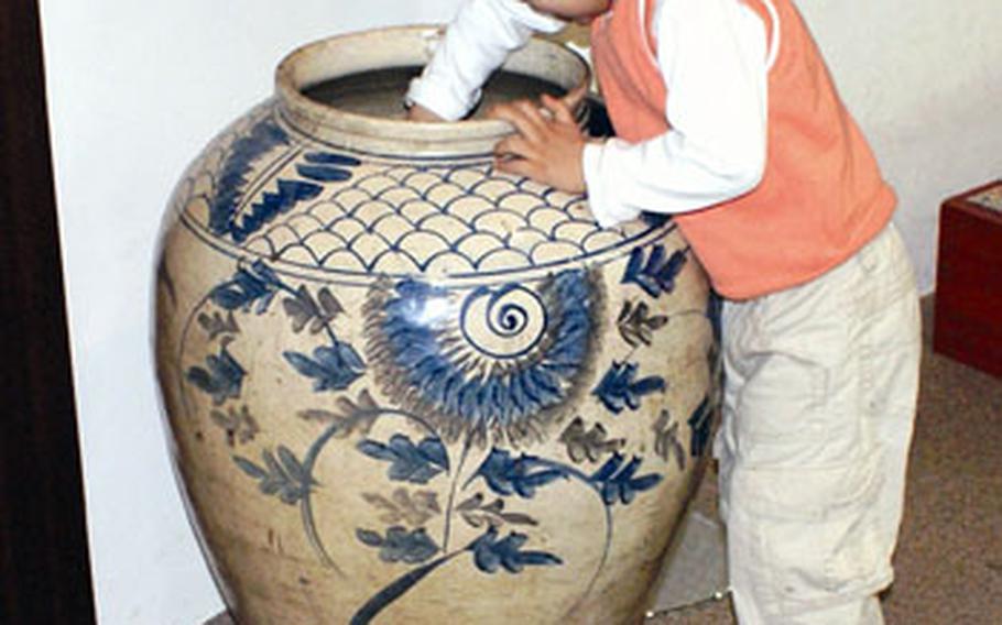 Diego Jimenez puts his hand in a kimchi storage jar at the Kimchi Field Museum.
