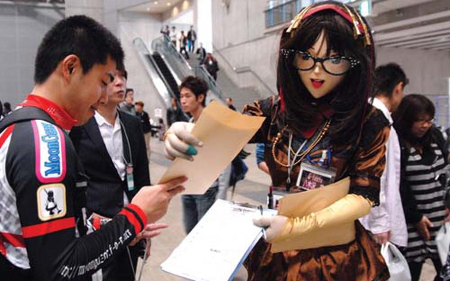 A woman in an anime character costume takes a merchandise order from a fan at the anime car show at Makuhari Messe.