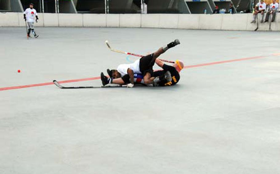Players take a tumble during a recent CBHK (Canada Ball Hockey Korea) game in Seoul, South Korea. While fighting and bone-crunching checks are not allowed, the league does feature some pretty aggressive play and occasional injuries.