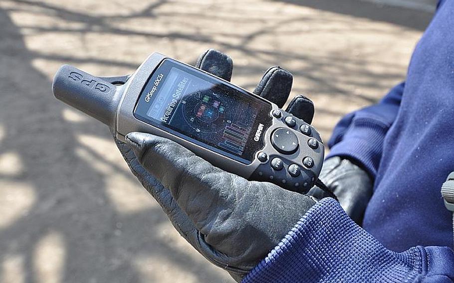 Tech. Sgt. Robert Slagle checks the satellite strength on his hand-held GPS device during a demonstration in Misawa City in April. Slagle is president of the Misawa Geocachers Organization at Misawa Air Base, Japan.