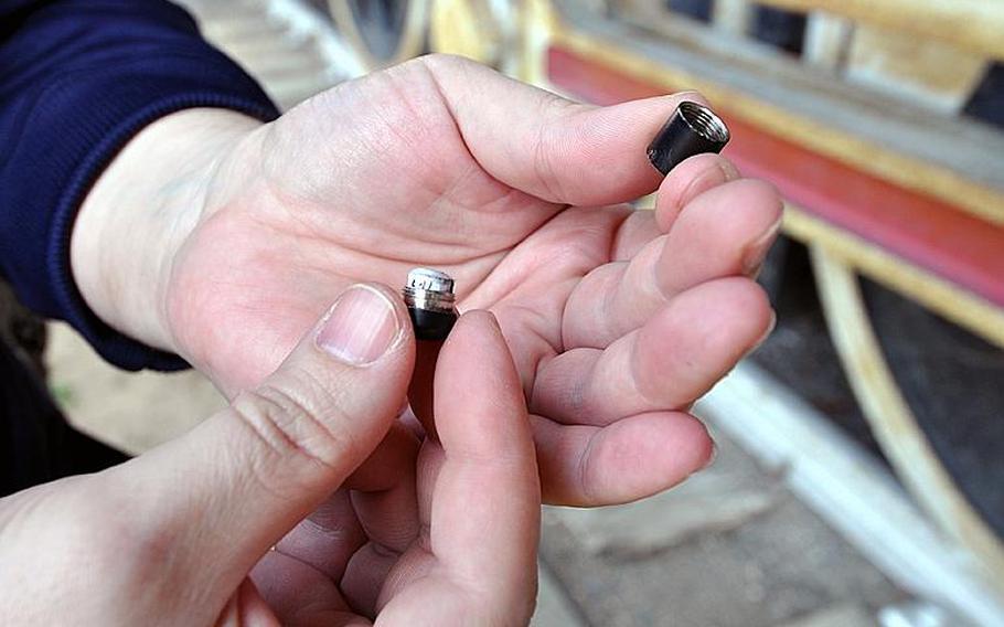Tech. Sgt. Robert Slagle displays a magnetic nano-cache, smaller than the tip of his pinky finger, during a geocaching demonstration in Misawa City in April. Slagle is president of the Misawa Geocachers Organization at Misawa Air Base, Japan. Club members use GPS coordinates to conduct high-tech treasure hunts and Slagle hid this nano-cache in a park near Misawa's front gate.