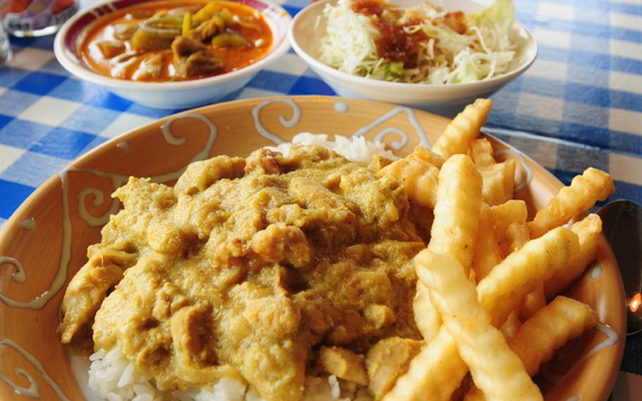At Okinawa&#39;s Fab Curry Buffet, a meal fit for a hungry king: Indian chicken curry, French fries, a bowl of yellow Thai chicken curry, and a salad with soy sauce and sesame and a cold iced tea.