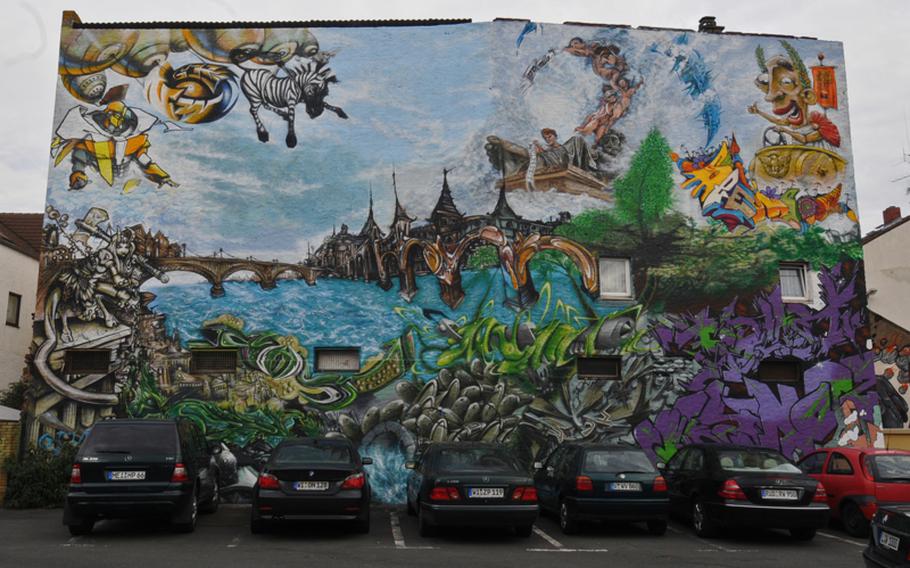 This large mural in Mainz-Kastel claims to show the town's Roman past. It was painted by 20 artists who were authorized to do so by the owner who offered it for their use. The wall borders a public parking in rear.