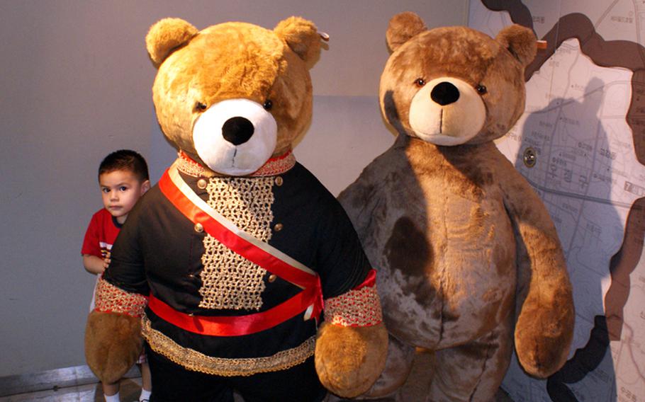 Diego Jimenez, 3, hides behind two oversize teddy bears at the Teddy Bear Museum.