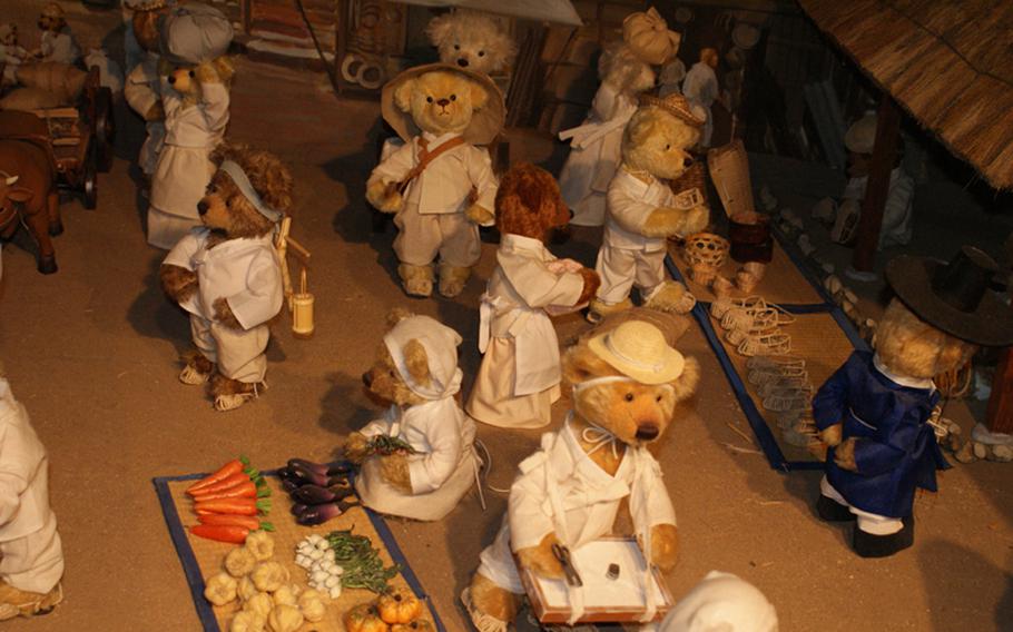 Teddy bears are showcased during the hustle and bustle of a traditional open marketplace.
